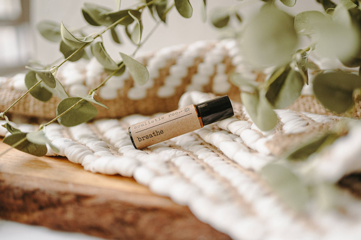 Soulistic Root Breathe Roller with essential oils, showing a clear glass roller bottle with a white label and natural oil inside.